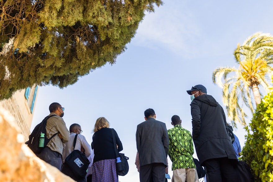 Des délégués se tiennent à l’ombre des cyprès au manoir de Mazra’ih.