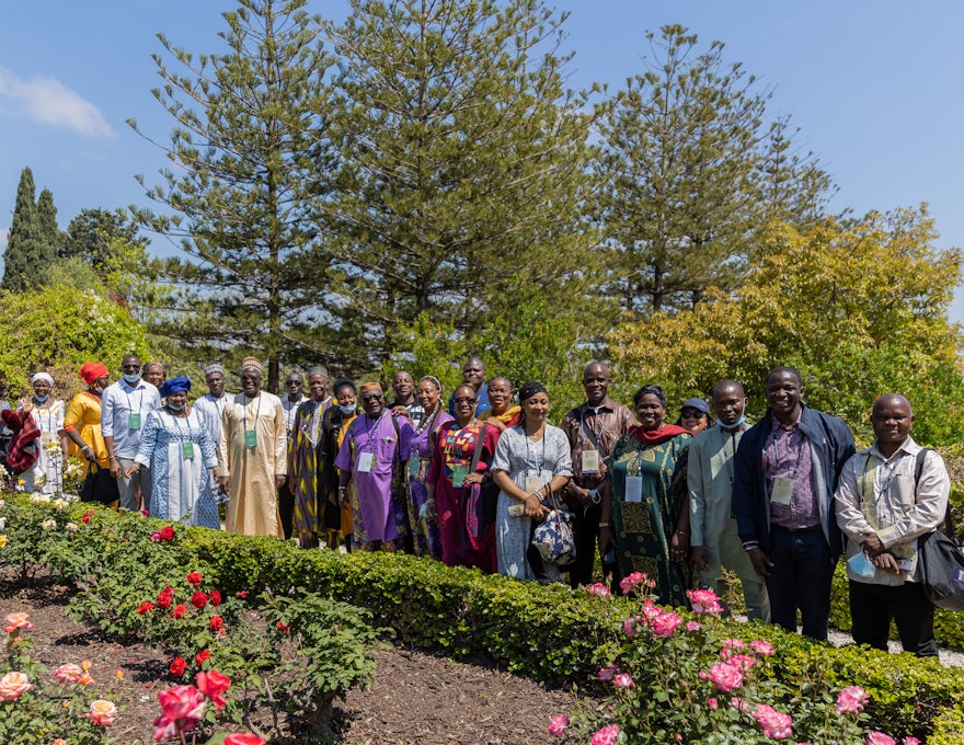 A group of Convention participants from various countries throughout Africa gather   in the gardens of the Mansion of Mazra‘ih.