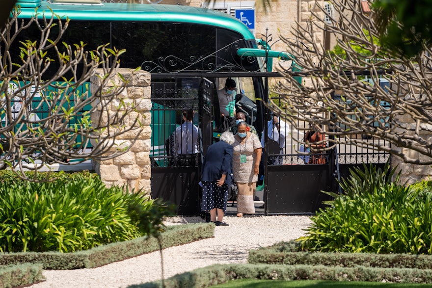 نمایندگان وارد دروازه‌های زائرسرای سابق در نزدیک بیت حضرت عبدالبهاء در حیفا می‌شوند.