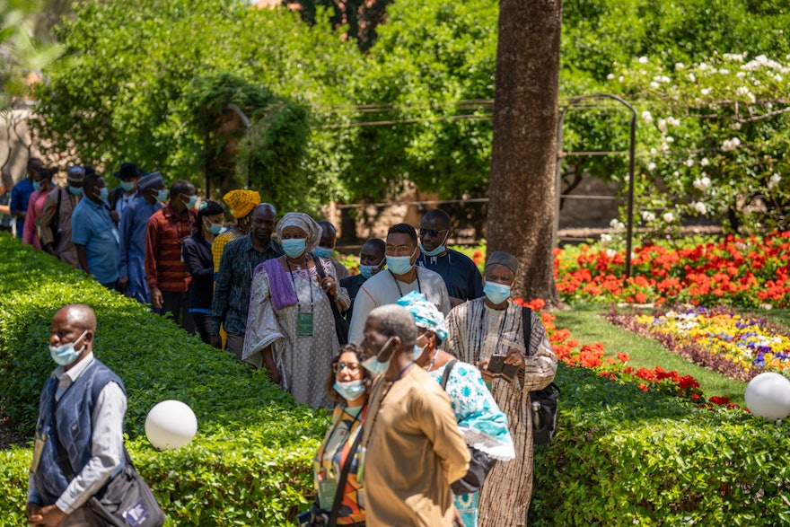 Délégués se promenant dans les jardins de la maison de ‘Abdu’l-Bahá.