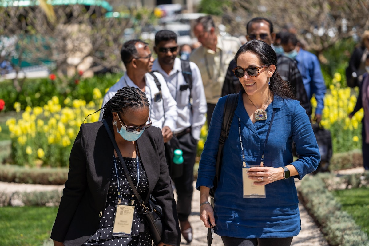 Convention participants from the United States and Zambia approach   the former Pilgrim House near the House of ‘Abdu’l-Bahá.