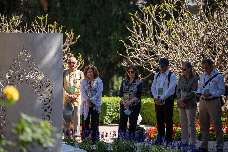 Delegates from Ecuador reverently stand at the resting place of Amatu'l-Bahá Rúhíyyih Khánum.