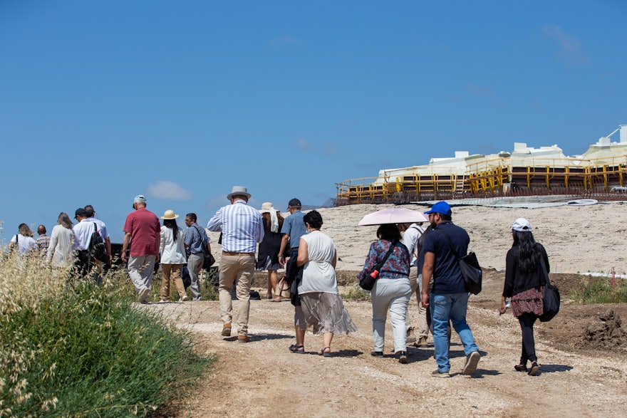 Des représentants et des invités commencent leur visite guidée sur le chantier de construction du mausolée de ‘Abdu’l-Bahá.