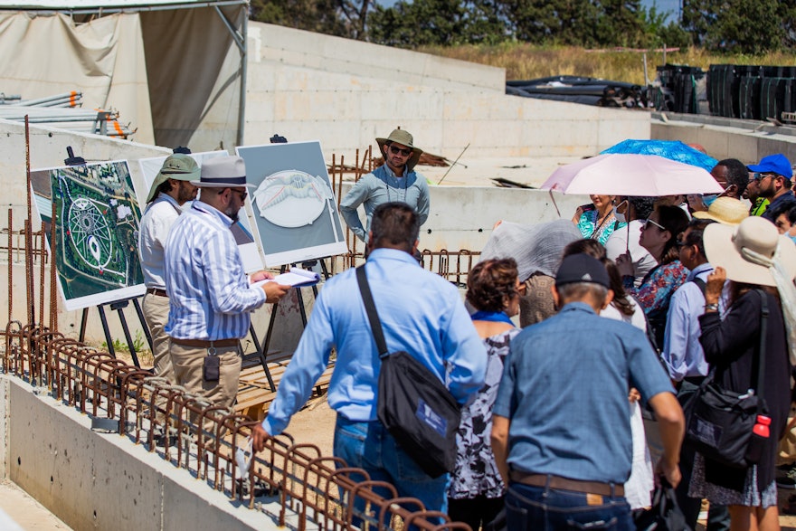 Delegates listen to a presentation at the south plaza of the future Shrine of ʻAbdu'l-Bahá during their visit.