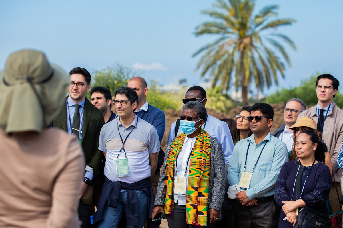 Delegates and other guests listen to a presentation at the site of the future Shrine of ʻAbdu'l-Bahá’s.