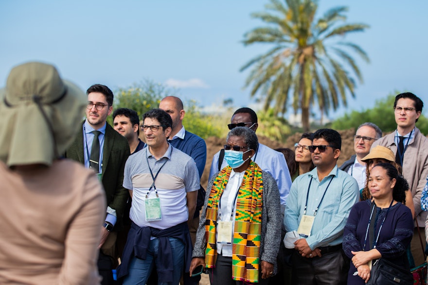 Des délégués et d’autres invités écoutant une présentation sur le site du futur mausolée de ‘Abdu’l-Bahá.