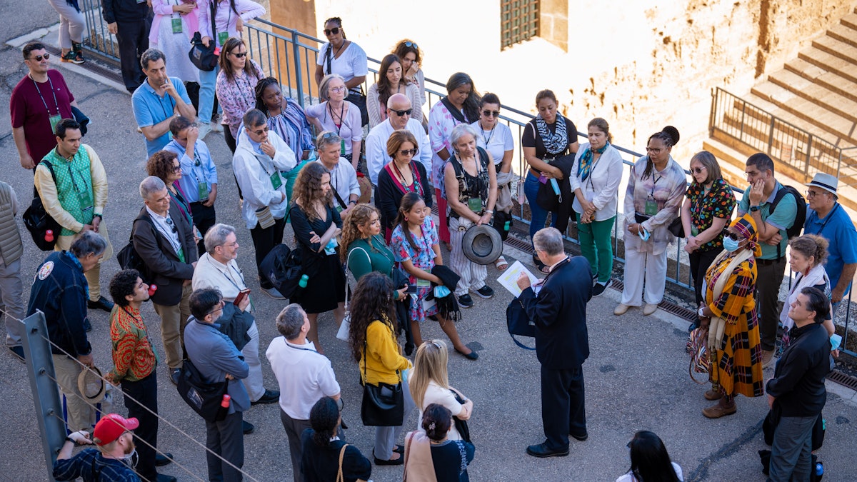 Delegates gathered in the courtyard of the ‘Akká citadel listen to   a guide on their visit to the Prison Cell.