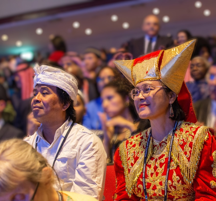 A delegate from Indonesia listens to opening remarks of the 13th International Baha’i Convention.