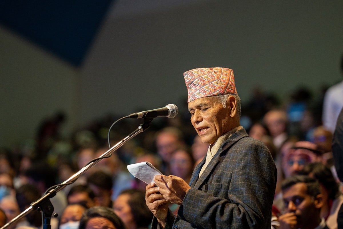 Делегат из Непала обращается к съезду во время совещательного заседания.