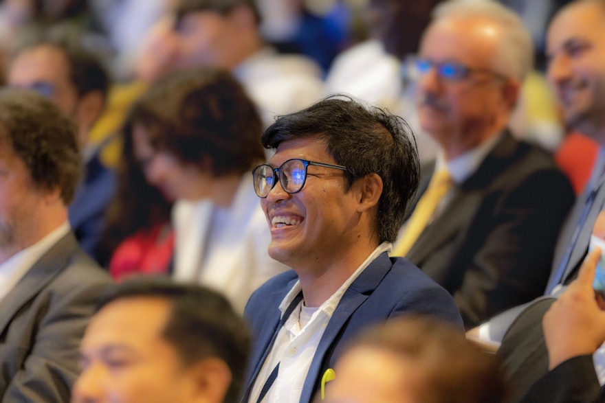 Un delegado de Camboya escucha emocionado los relatos compartidos por otro representante en la XIII Convención Internacional Bahá’í