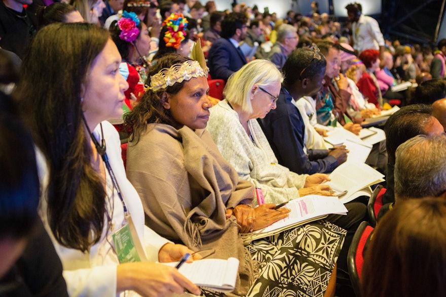 نماینده‌ای از کالدونیای جدید (در وسط ) در یکی از جلسات مشورتی در سیزدهمین کانونشن بین‌المللی بهائی.