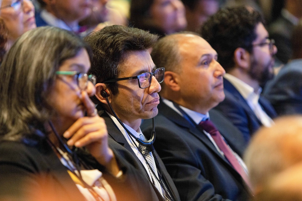 Delegates from Peru listen to live translations during a consultative session at the 13th International Bahá’í Convention.