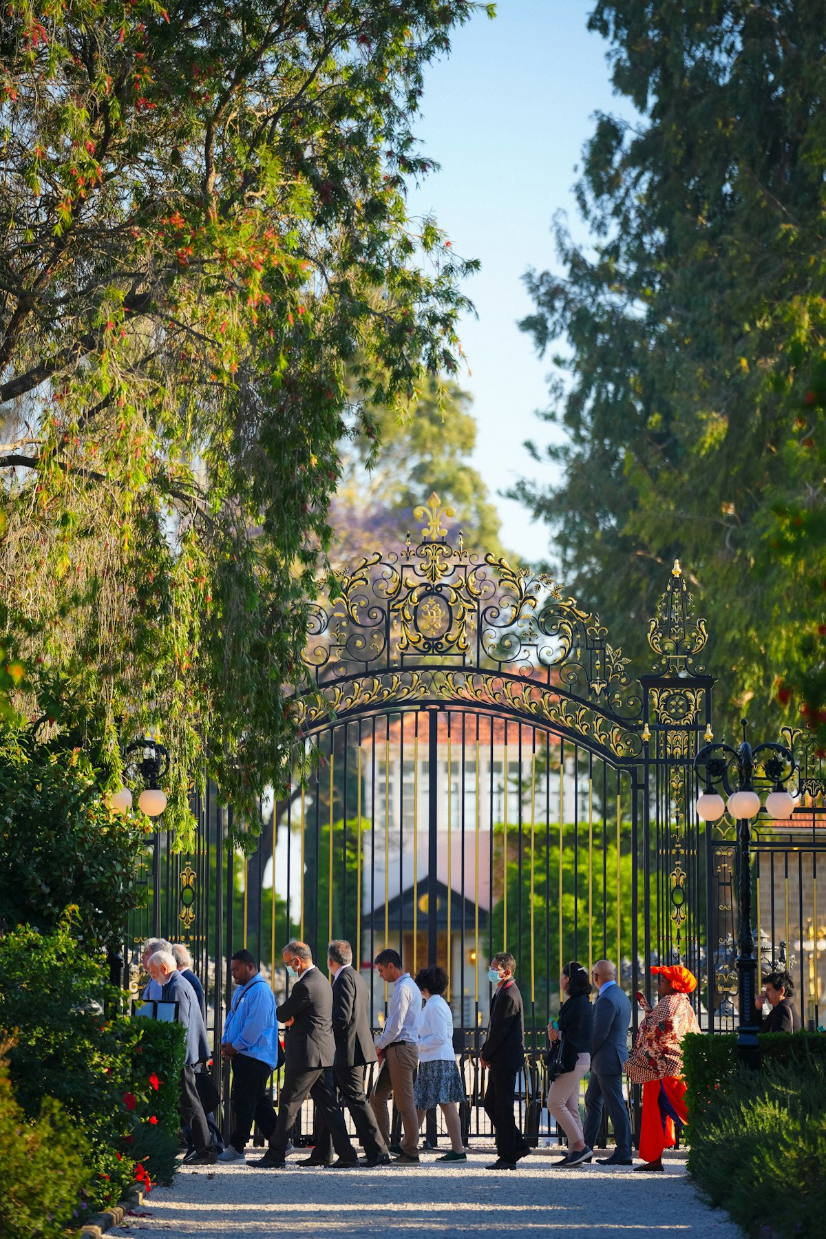 Los participantes de la Convención caminan junto a la Puerta Collins mientras circunambulan el Santuario de Baháʼu’lláh