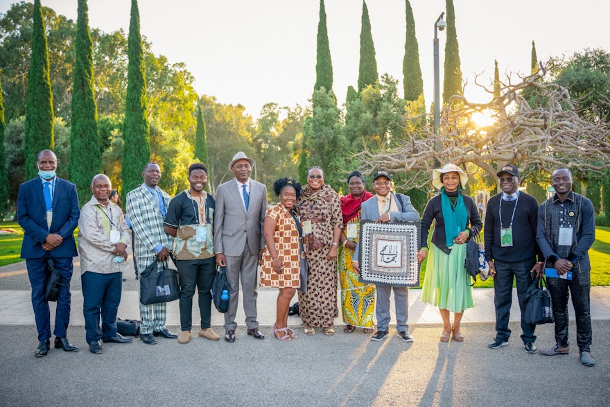 A delegate from the Democratic Republic of the Congo holds a painting gifted to the Bahá’í National Spiritual Assembly of that country by the National Assembly of Fiji. The painting features a sacred Bahá’í symbol known as the Greatest Name.