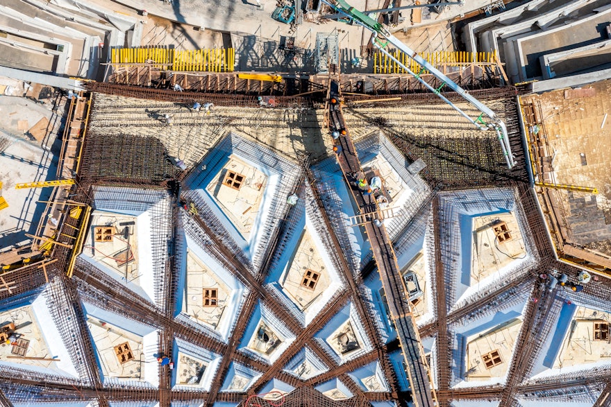 White architectural concrete is poured over the rebar on the north soffit area of the trellis.