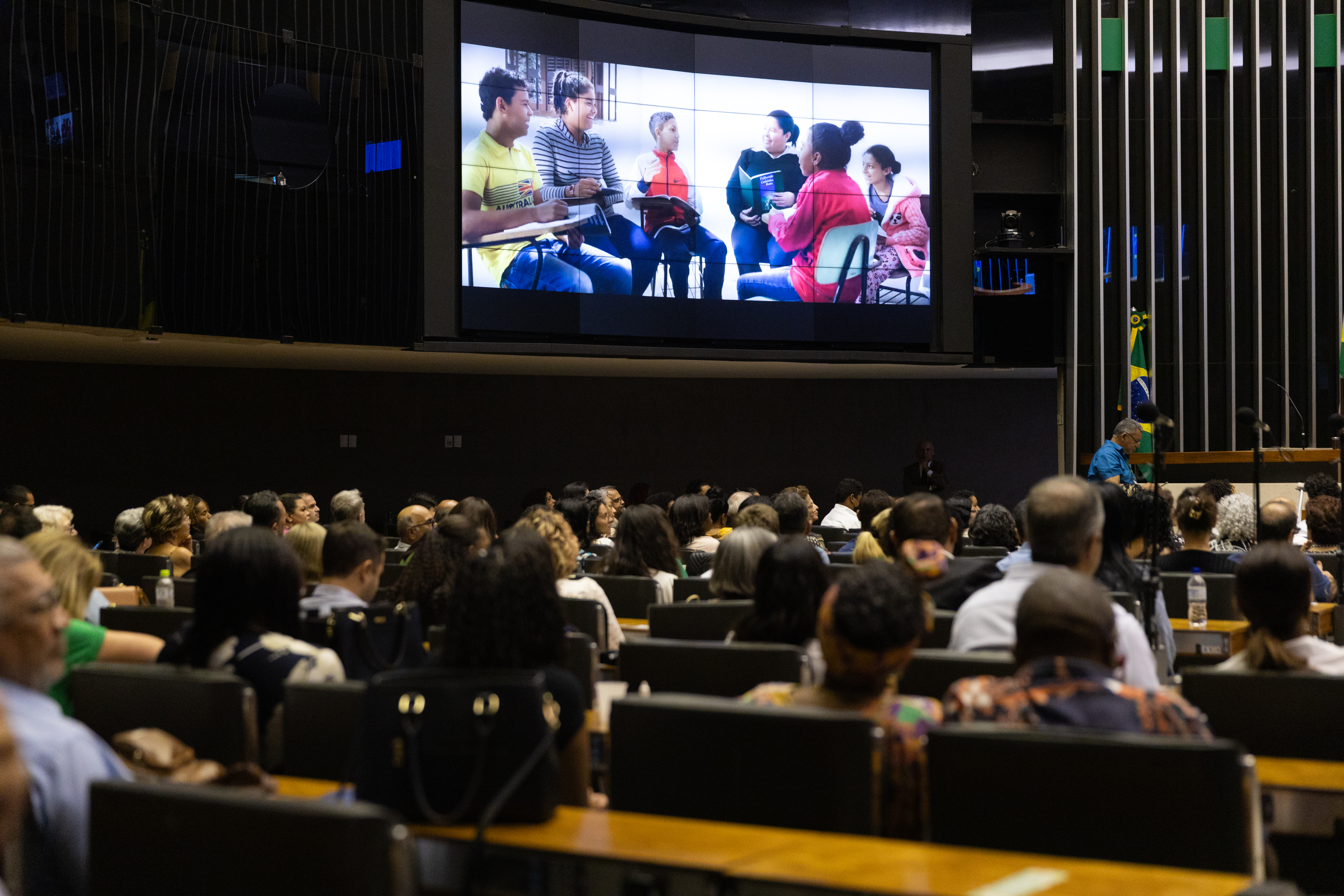 Attendees view an excerpt from the film “An expansive Prospect” which highlights the efforts of individuals, communities, and institutions in Brazil as they strive to channel the transformative power of the Bahá’í teachings toward the betterment of their society.