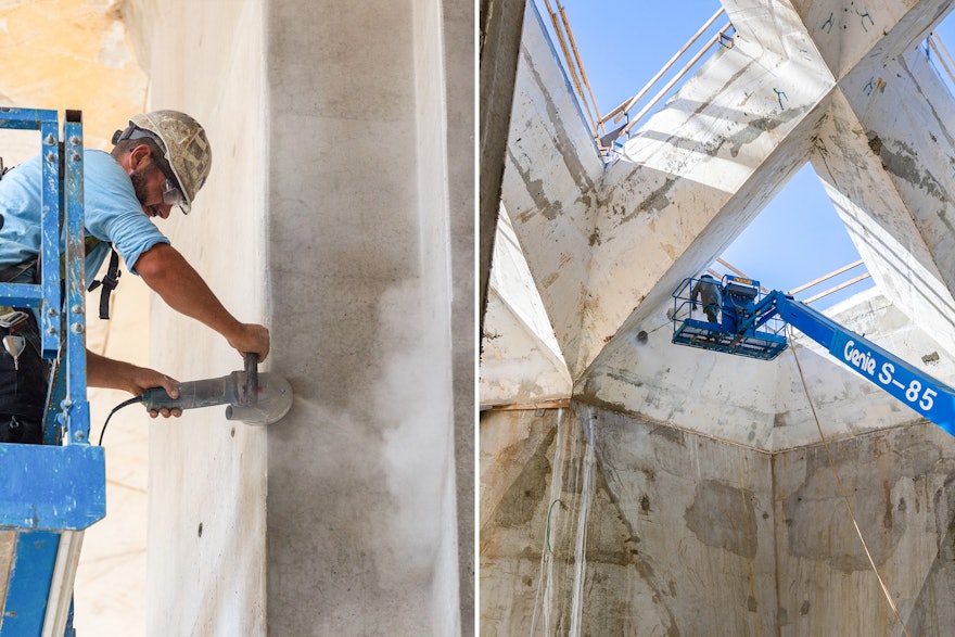 Workers refine variations in the concrete surface, preparing for the next stages of work.