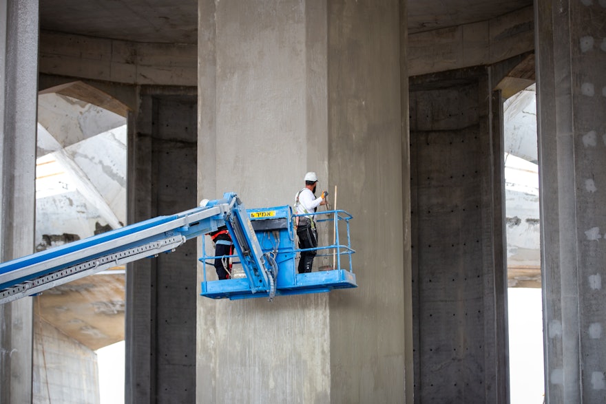 Une couche extérieure de béton est appliquée sur les piliers pour obtenir une surface lisse et uniforme.