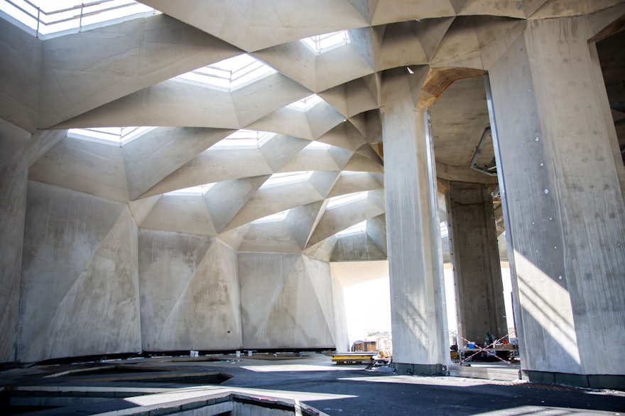 Early morning light filters through the openings in the now-complete trellis structure. The damp proofing layer has been applied to the concrete surface.