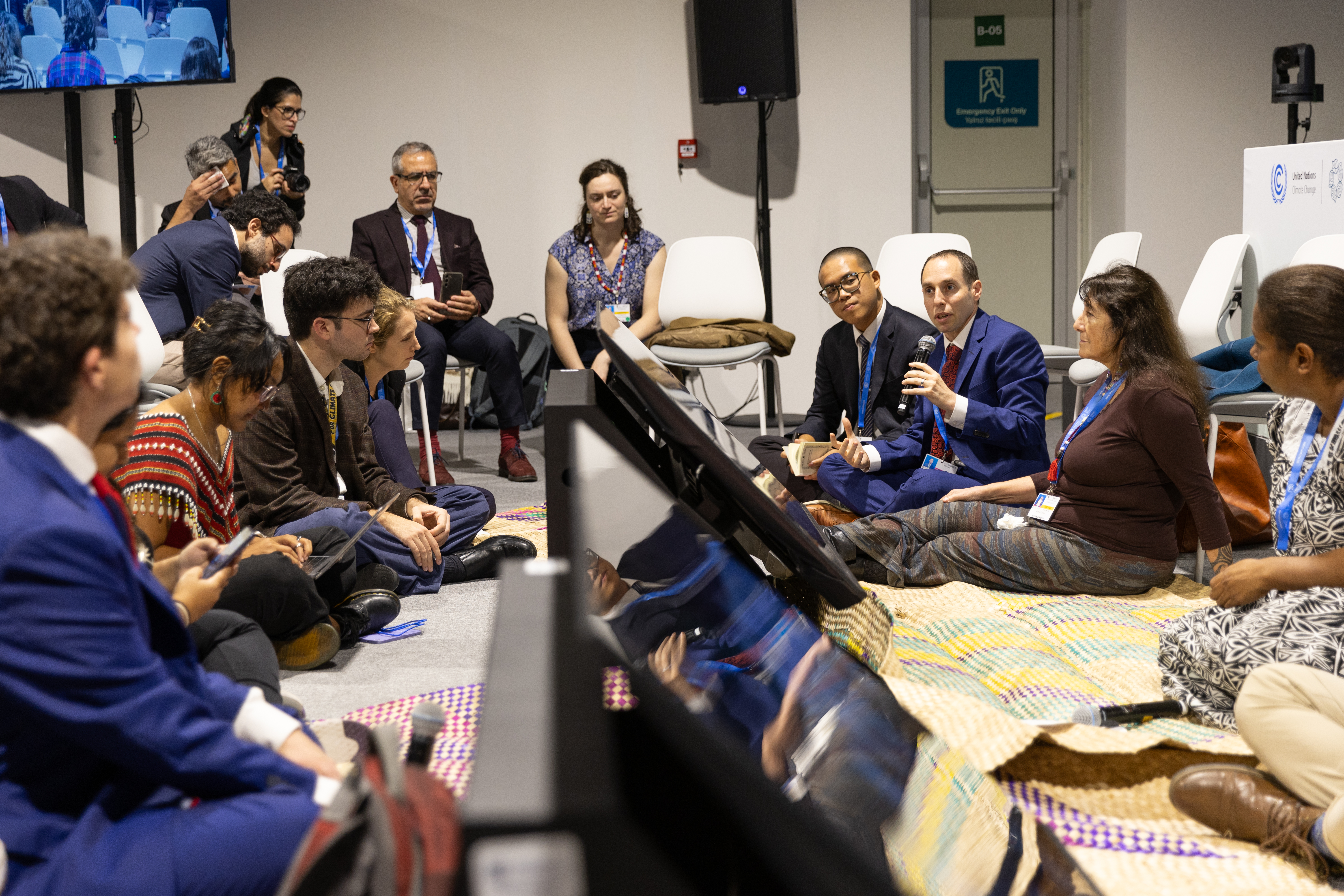 Daniel Perell, of the BIC’s New York Office, speaking at a side event co-hosted by the BIC and the Government of Vanuatu, where the discussion took the form of a ‘Tok stori’—a practice of sitting in a circle on mats to share perspectives. Photo credit: UN Climate Change – Kiara Worth