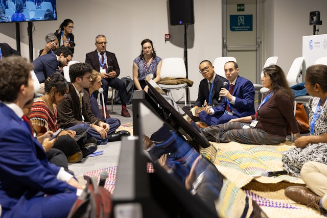 Daniel Perell, of the BIC’s New York Office, speaking at a side event co-hosted by the BIC and the Government of Vanuatu, where the discussion took the form of a ‘Tok stori’—a practice of sitting in a circle on mats to share perspectives. Photo credit: UN Climate Change – Kiara Worth