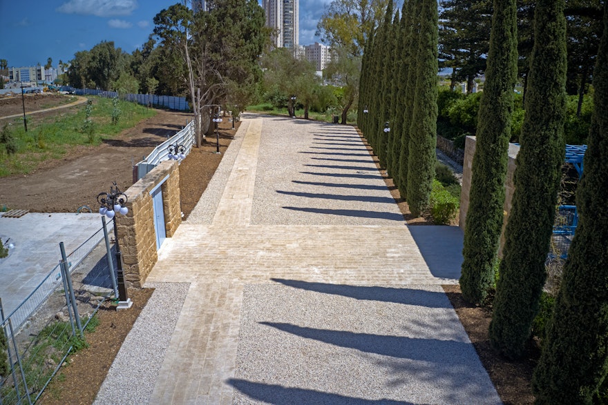 View of the historic path leading visitors to the Riḍván Garden (right) now completed and made accessible with new paving and white pebbles. The ‘Alí-Ashraf Gate, where future visitors will enter the Shrine, is seen on the left.