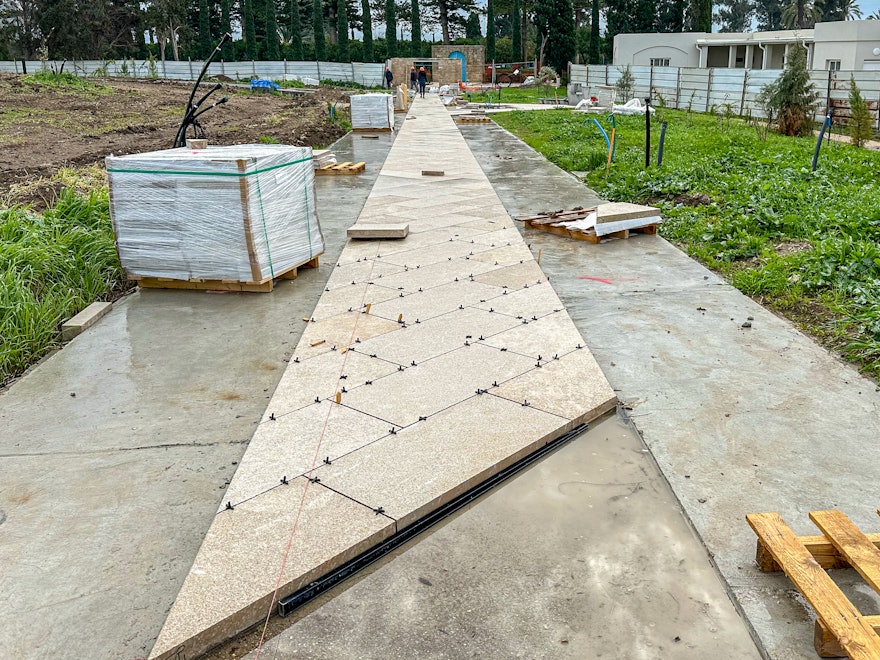 Paving of the entry path that will welcome visitors arriving from the ‘Alí-Ashraf Gate to the south plaza.