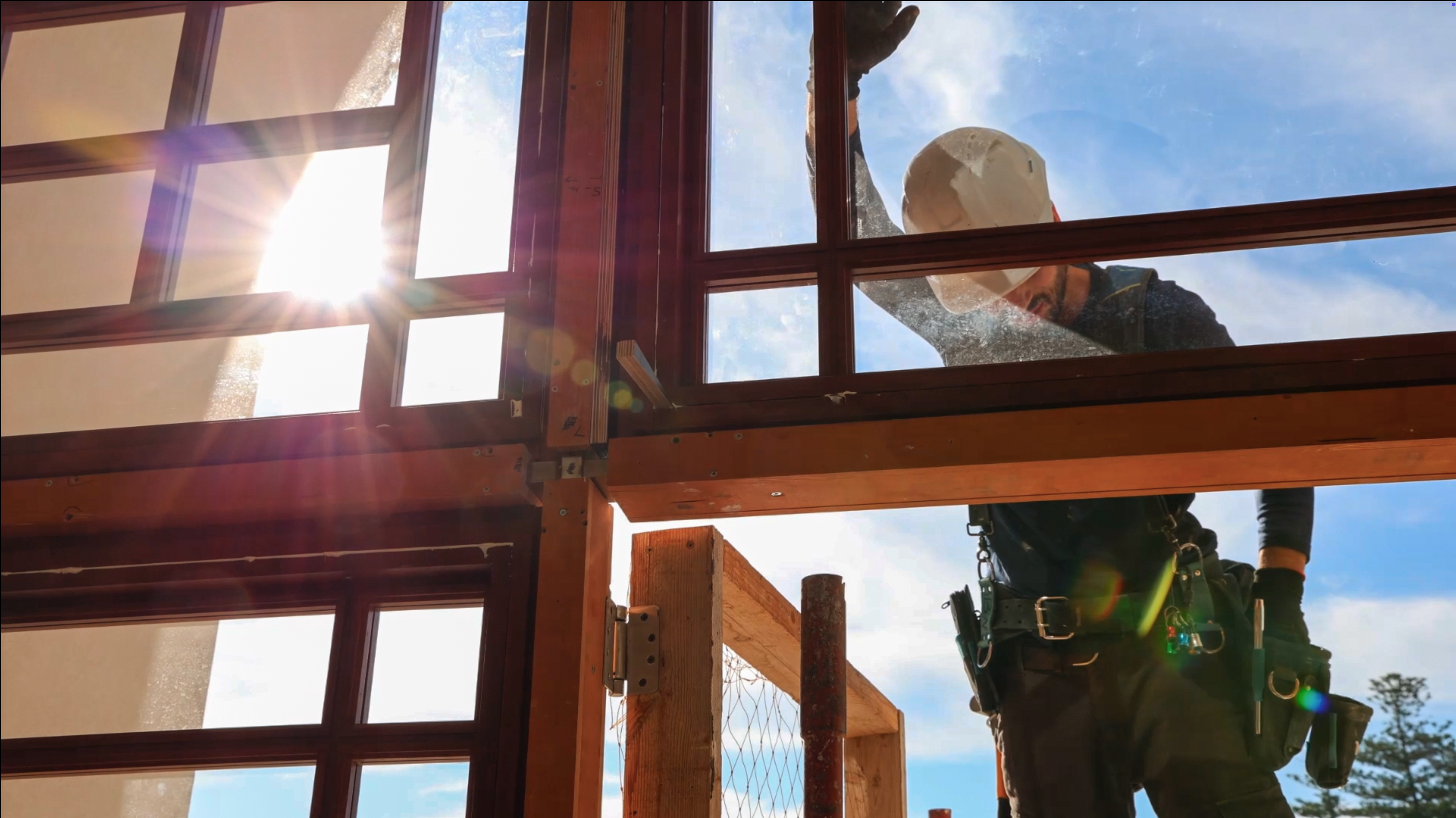 Looking out from within the ‘Akká Visitors’ Centre, a worker is installing a window as construction progresses on the building’s exterior access points.
