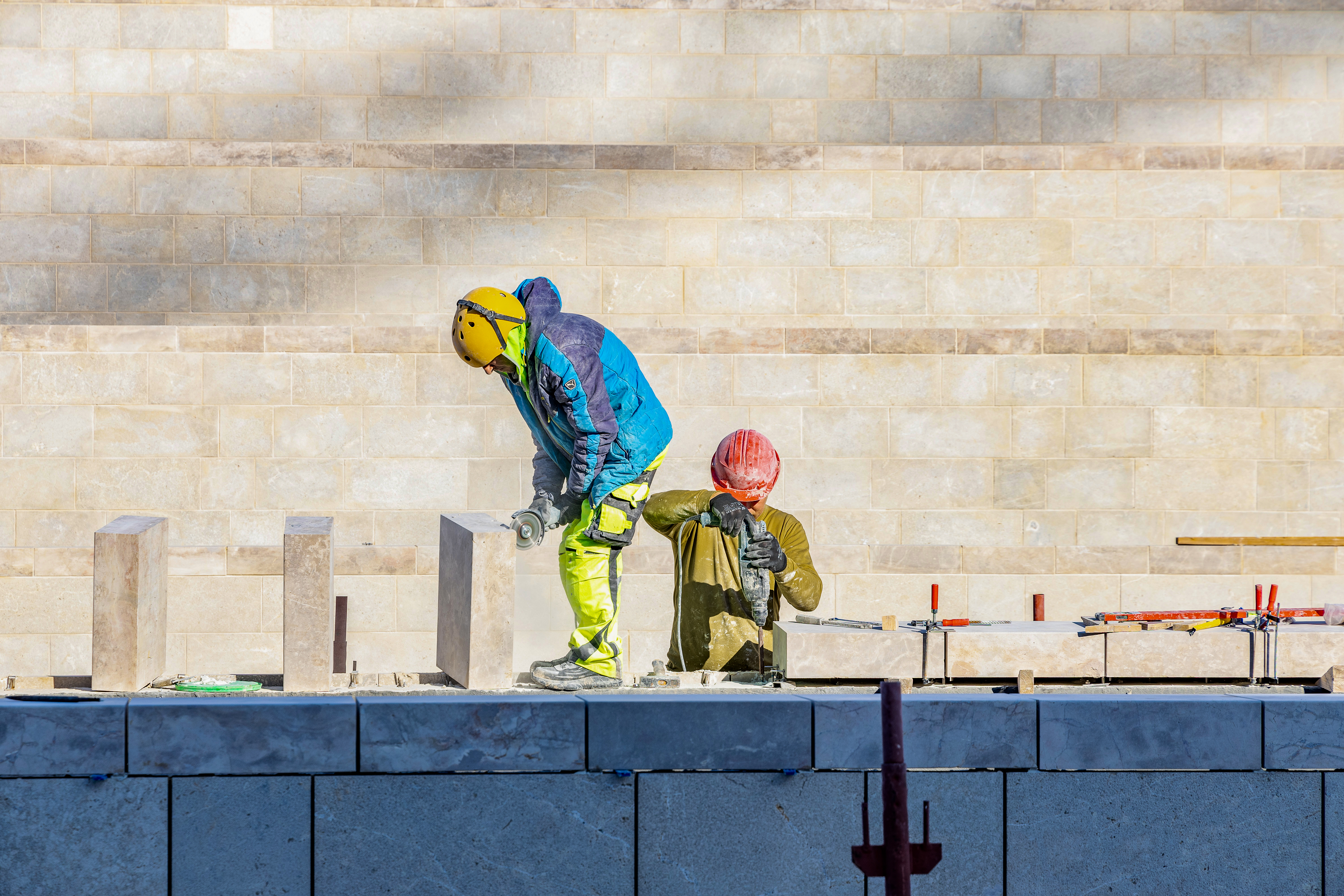 Workers placing local stone sourced from Bethlehem on the garden planters in the north plaza.