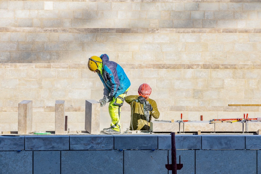 Workers placing local stone sourced from Bethlehem on the garden planters in the north plaza.
