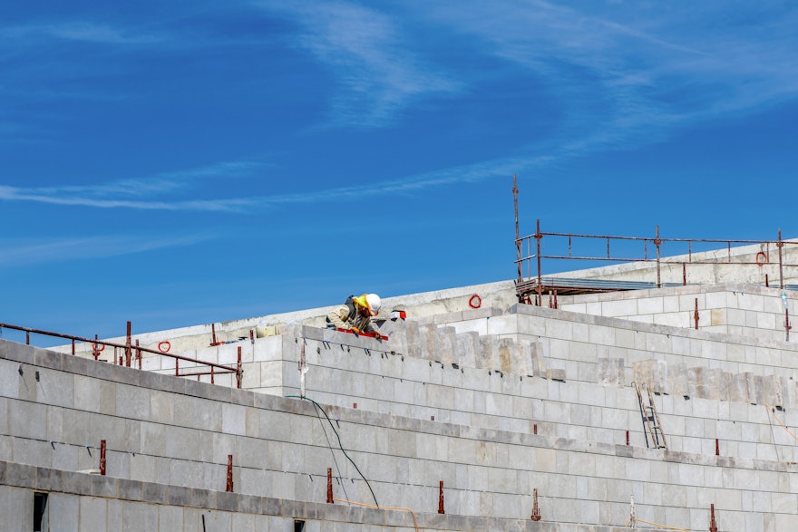 Local stone being placed on the walls of the garden planters in the south plaza.