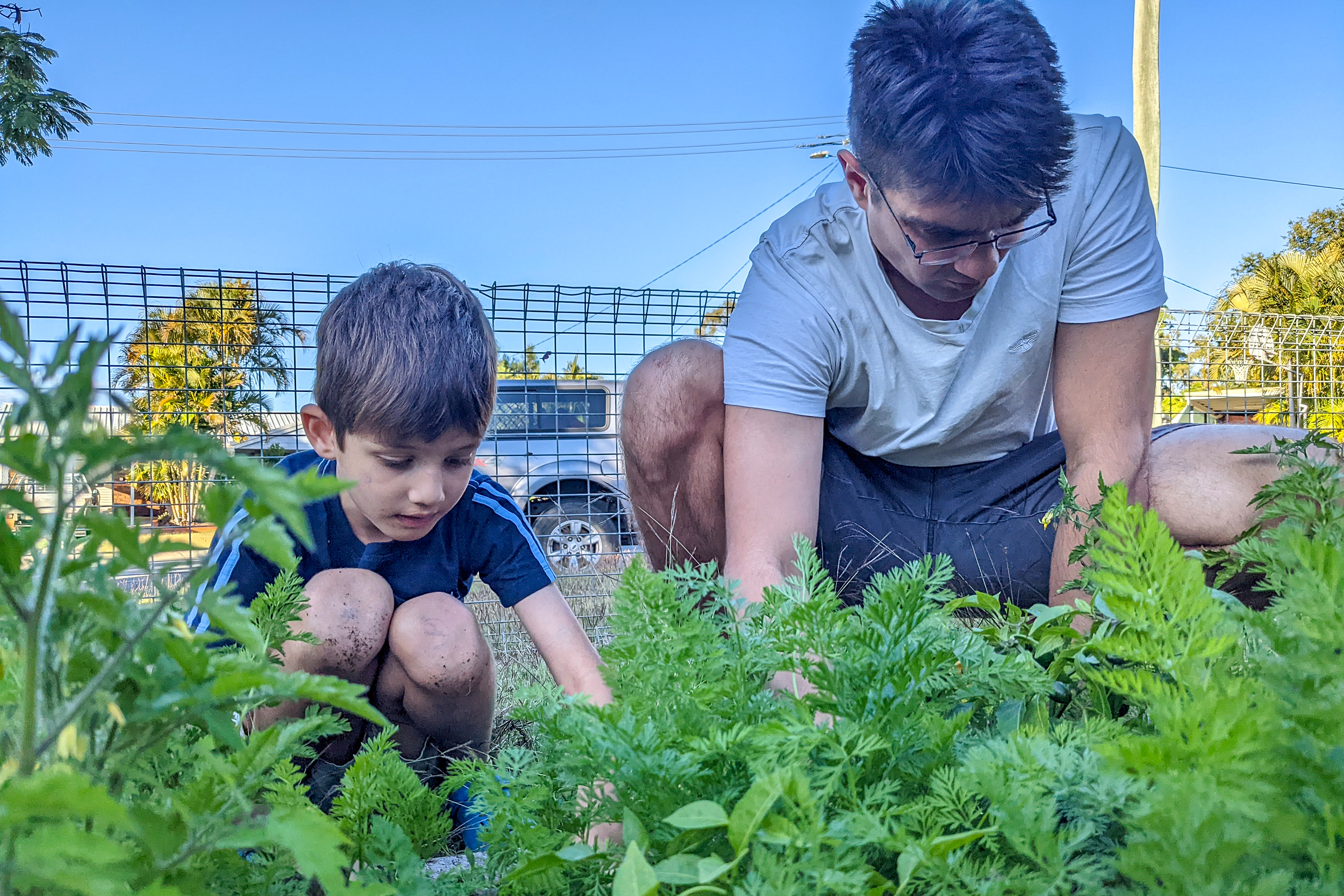 Un jeune et un enfant jardinent ensemble.
