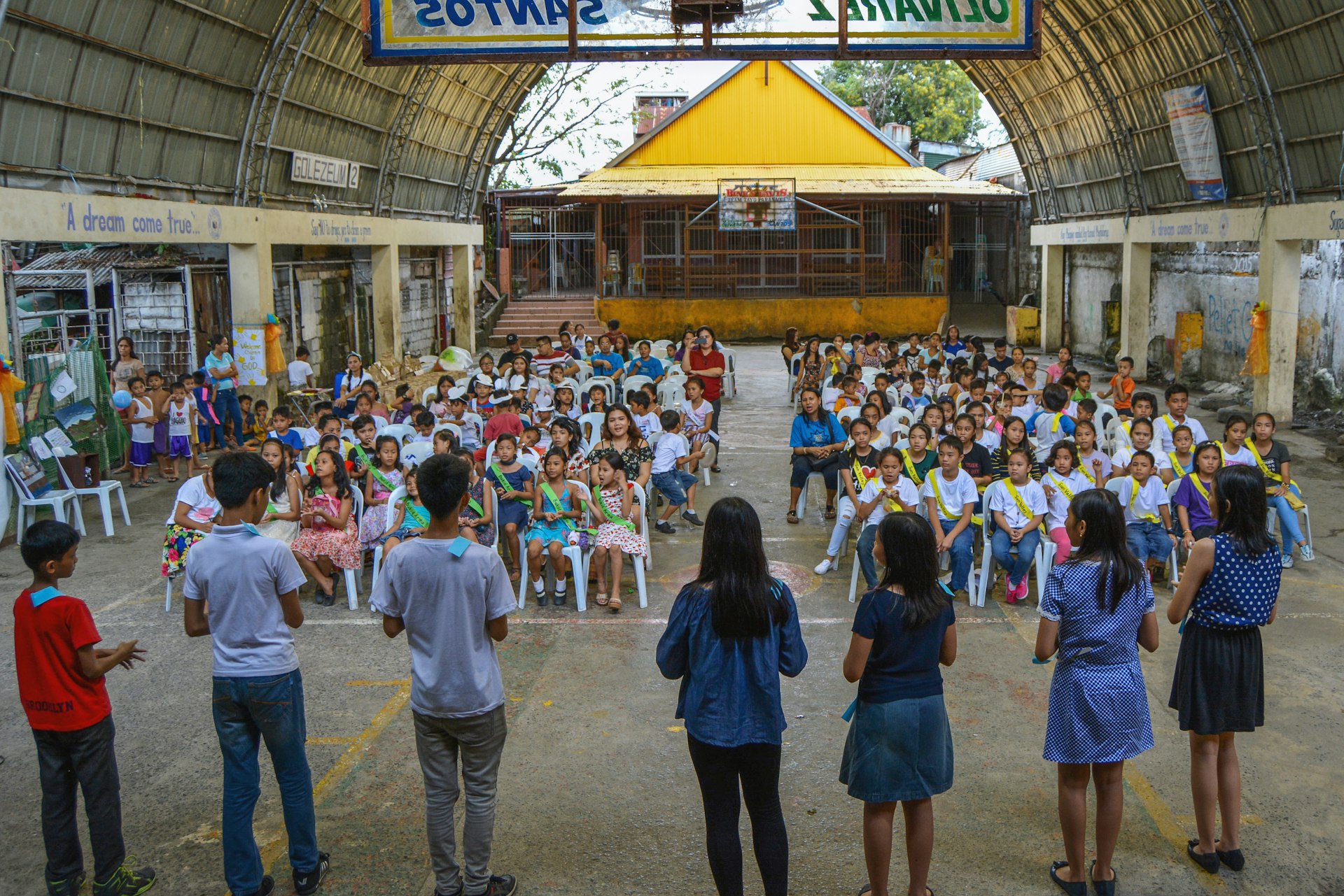 View of children participating in a neighborhood festival, as part of moral educational programs that nurture spiritual qualities—such as freedom from prejudice, love, justice, and unity—in younger generations.