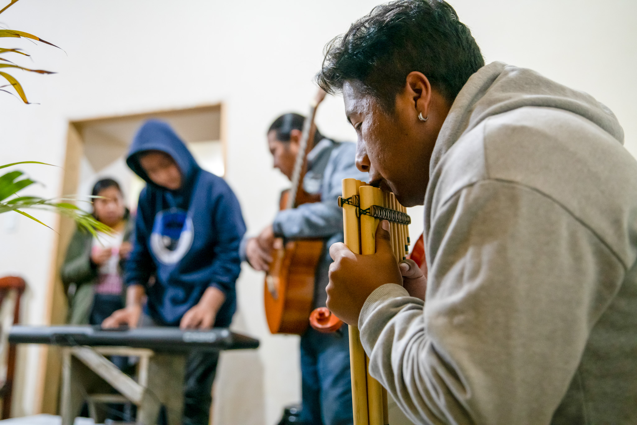 A participant playing the zampoña (Andean panpipes)—a traditional wind instrument.