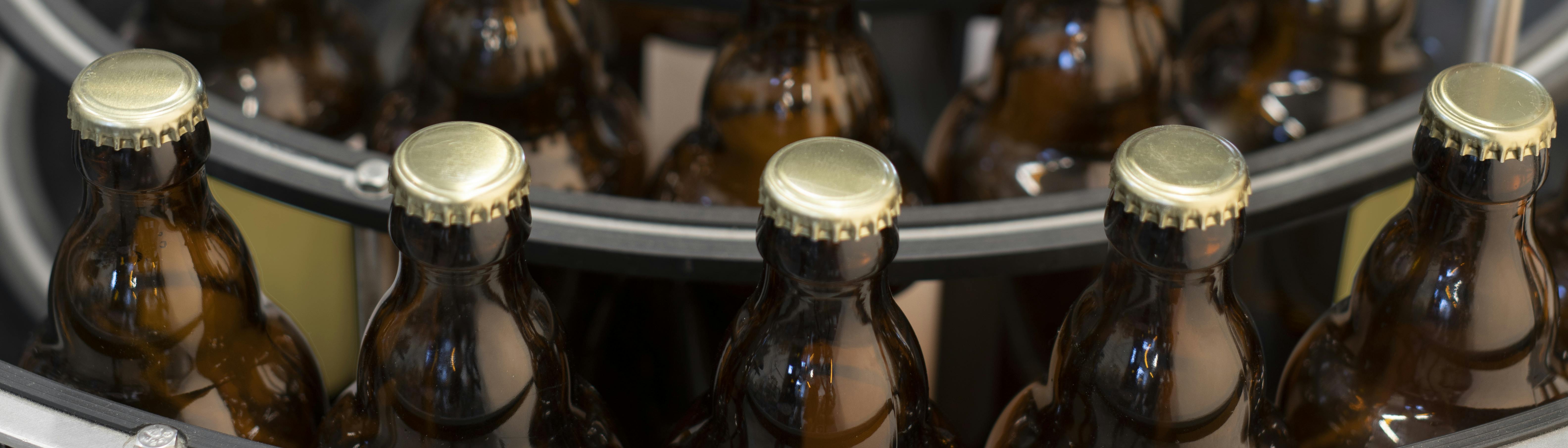 Una tavola indicata per l'accumulo di bottiglie, in questo caso vi sono collocate delle bottiglie di birra con tappo corona ed etichetta personalizzata Quinti