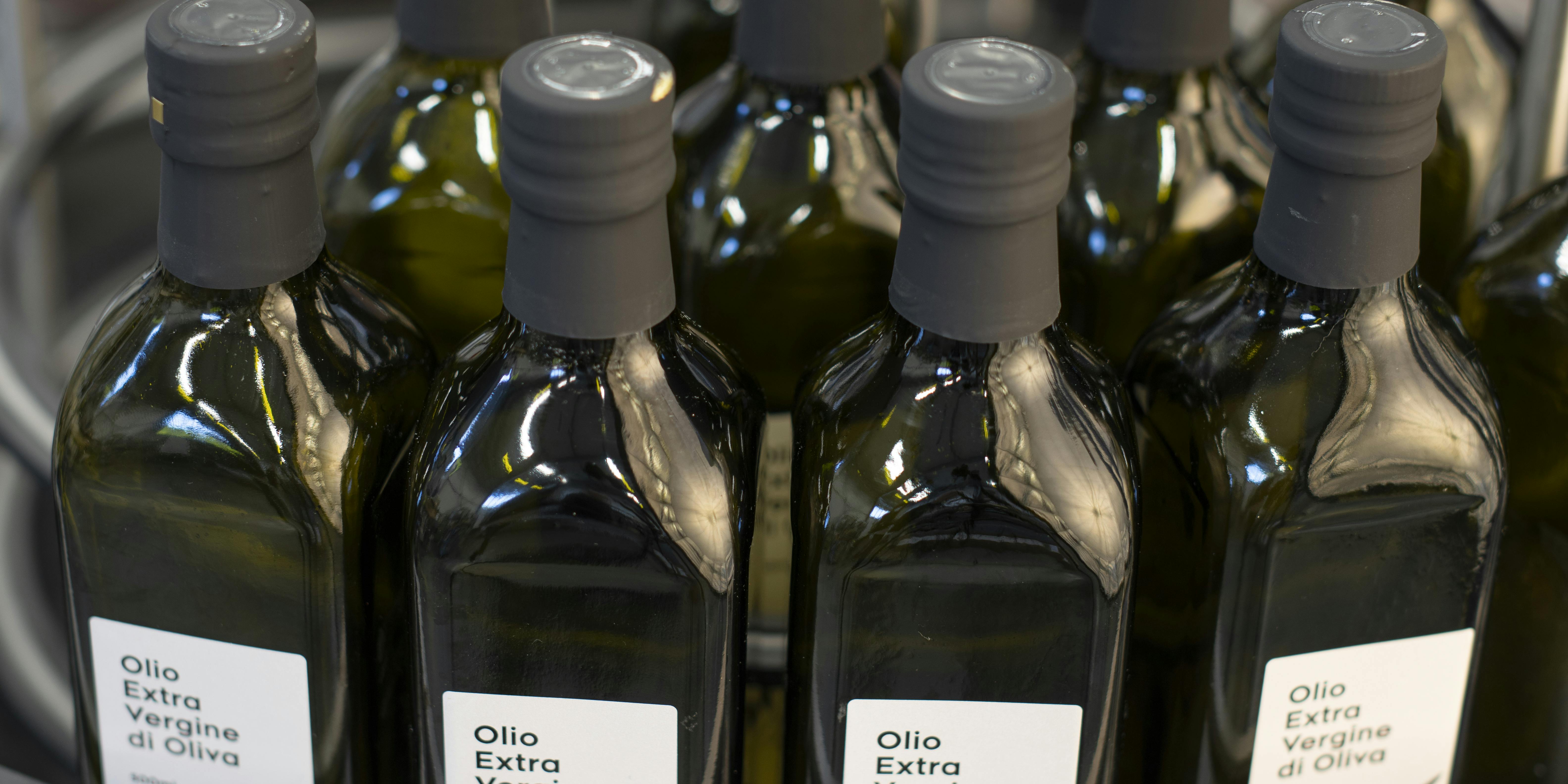 Una tavola indicata per l'accumulo di bottiglie, in questo caso vi sono collocate delle bottiglie di olio con capsula nera ed etichetta personalizzata Quinti