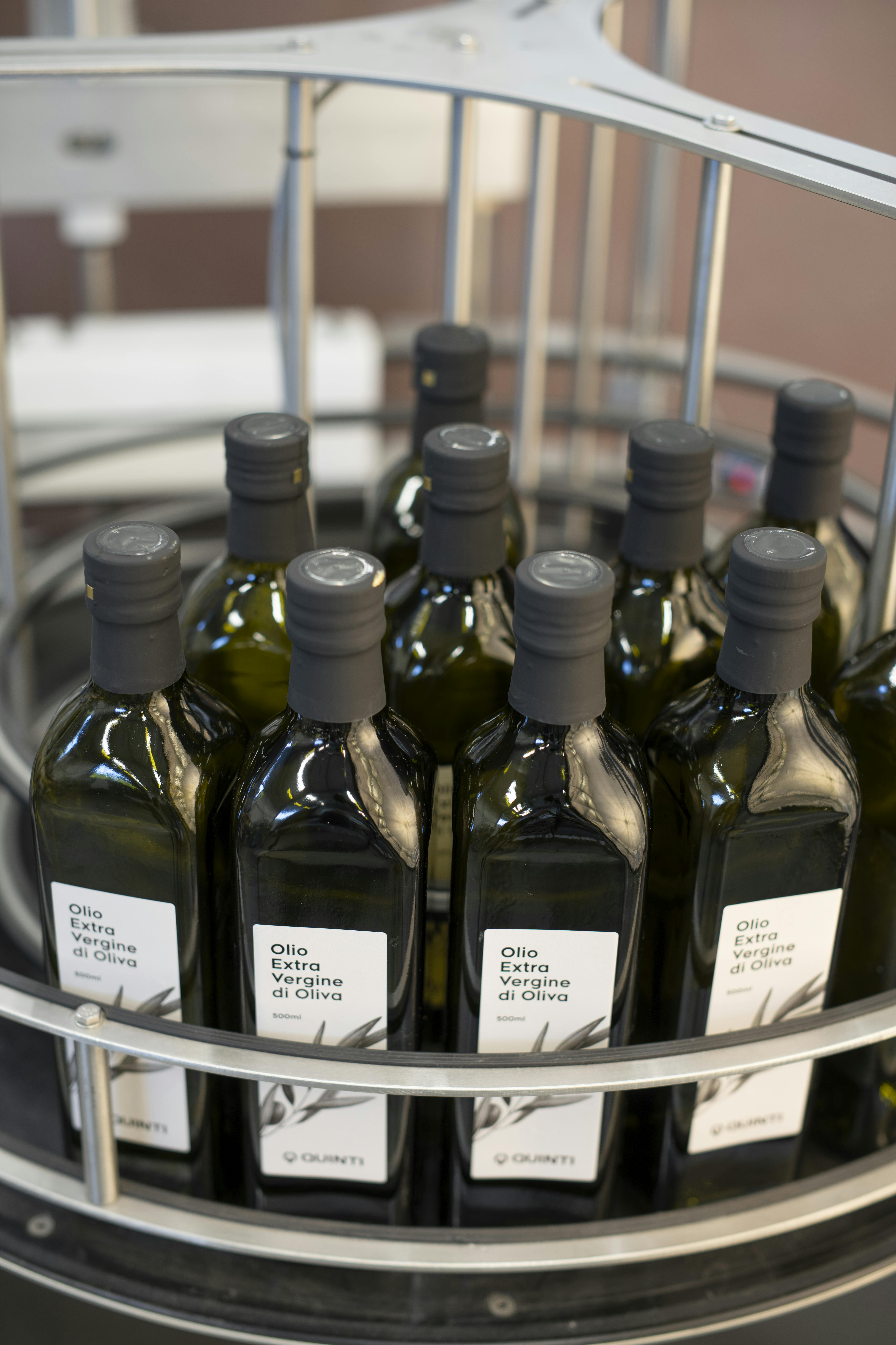 Una tavola indicata per l'accumulo di bottiglie, in questo caso vi sono collocate delle bottiglie di olio con capsula nera ed etichetta personalizzata Quinti