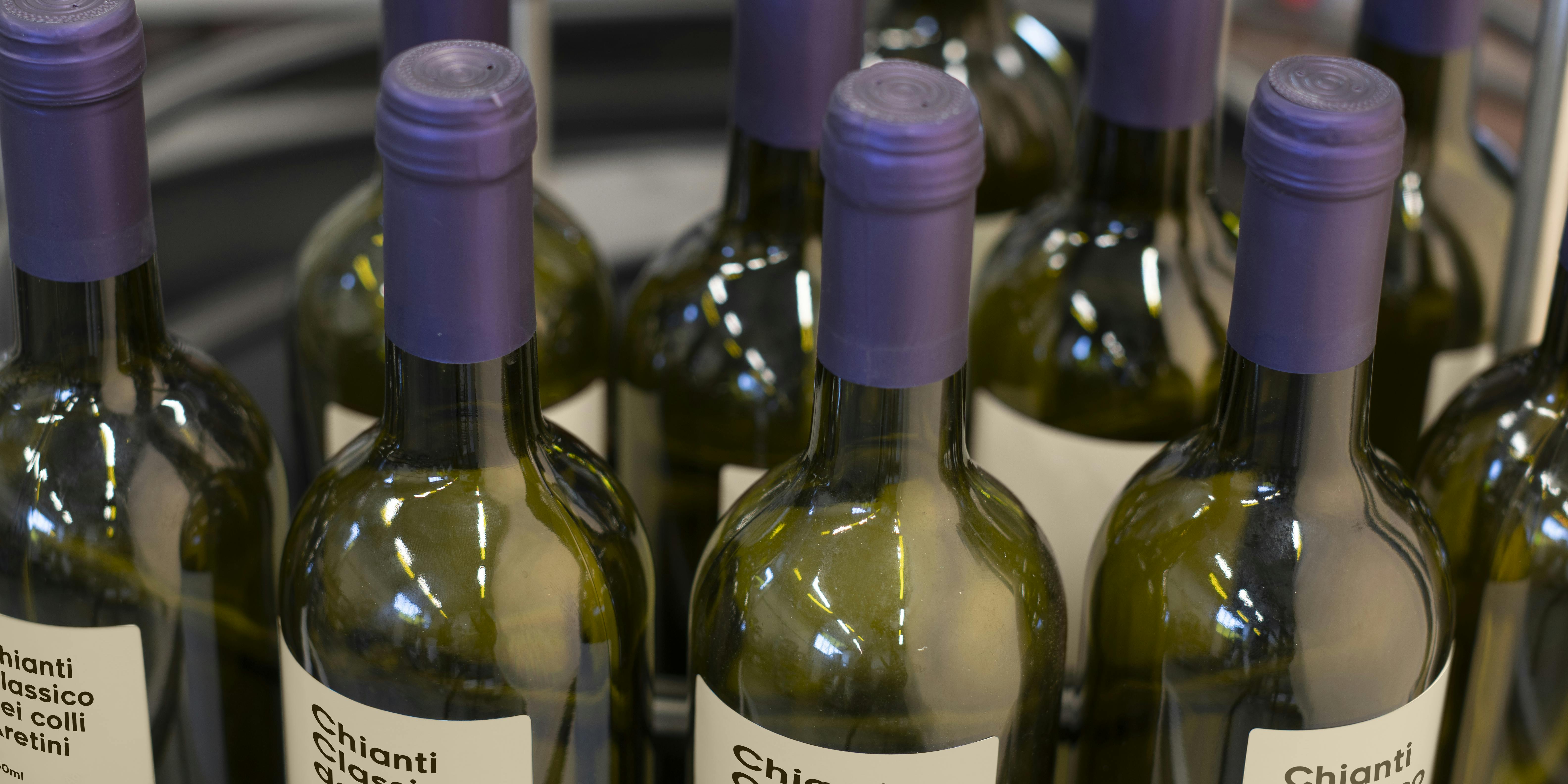 Una tavola indicata per l'accumulo di bottiglie, in questo caso vi sono collocate delle bottiglie di vino con capsula viola ed etichetta personalizzata Quinti