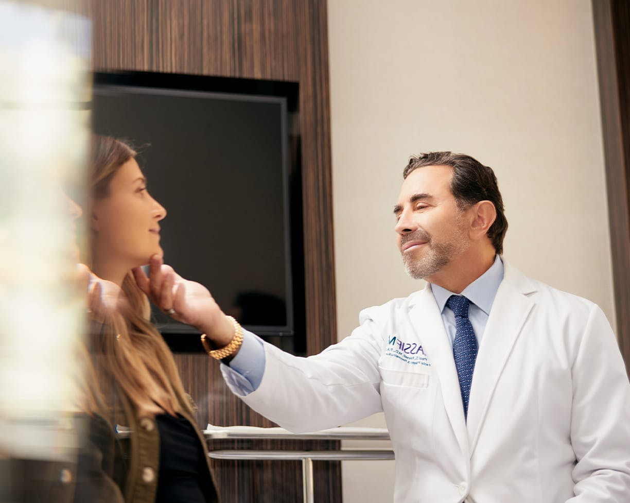 Dr. Paul Nassif looking at a female patient's face