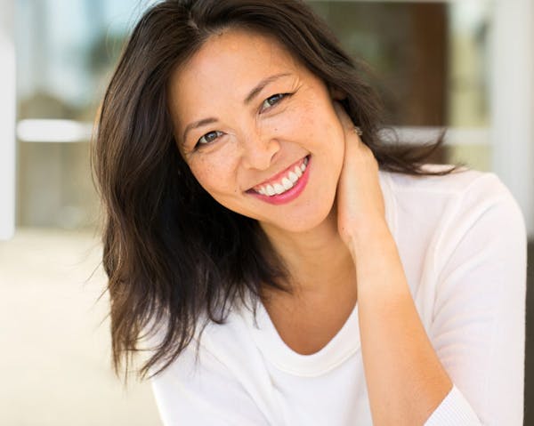 woman with short brownhair touching neck