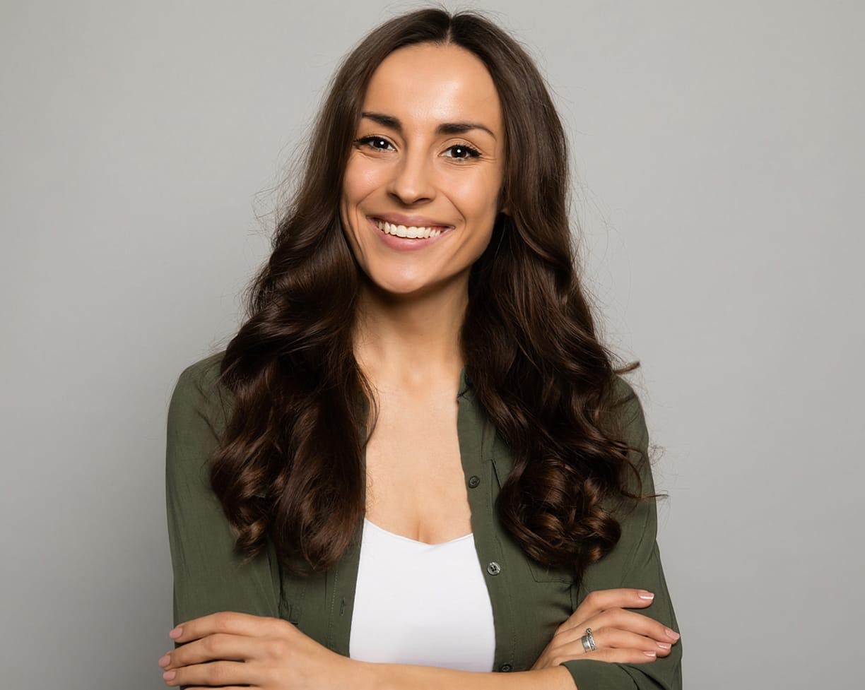 woman with wavy brown hair crossing arms