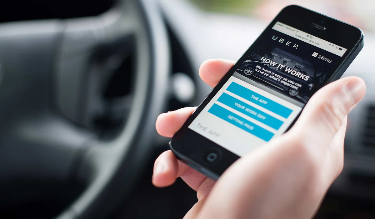 Person holding an iPhone with mobile Uber website displayed