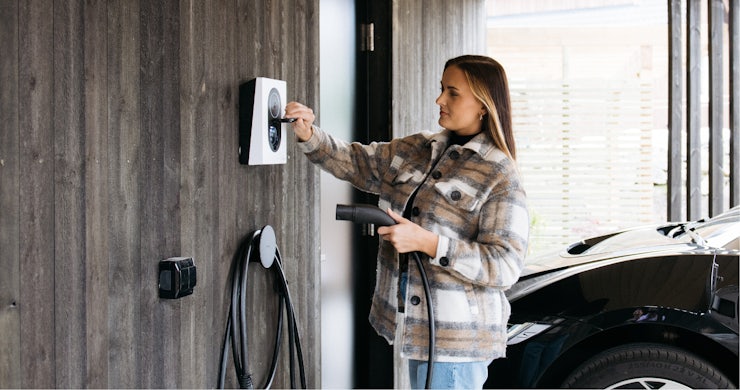 Naine ühendab oma autot laadimiskastiga.