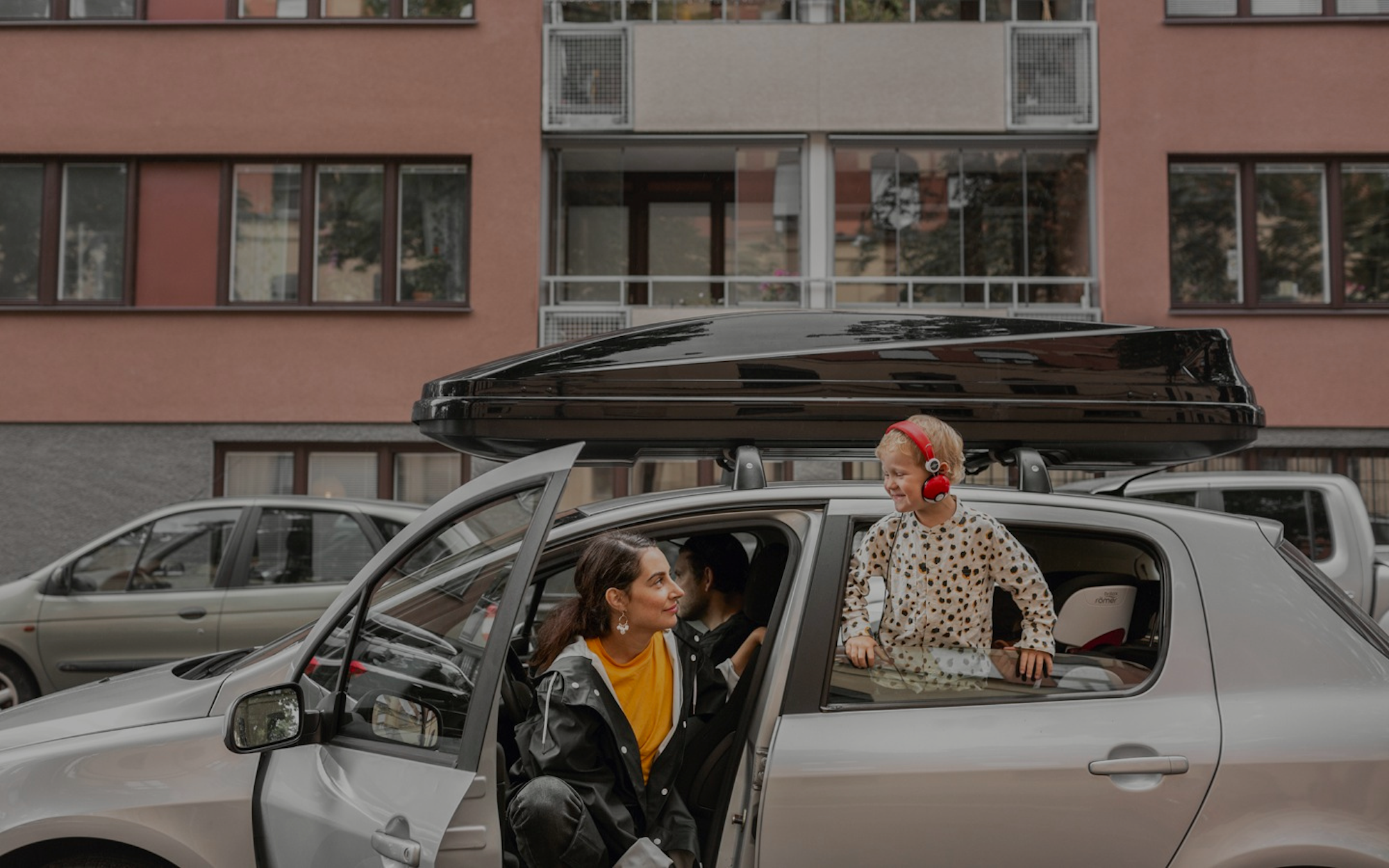 Familj vid sin bil med takbox