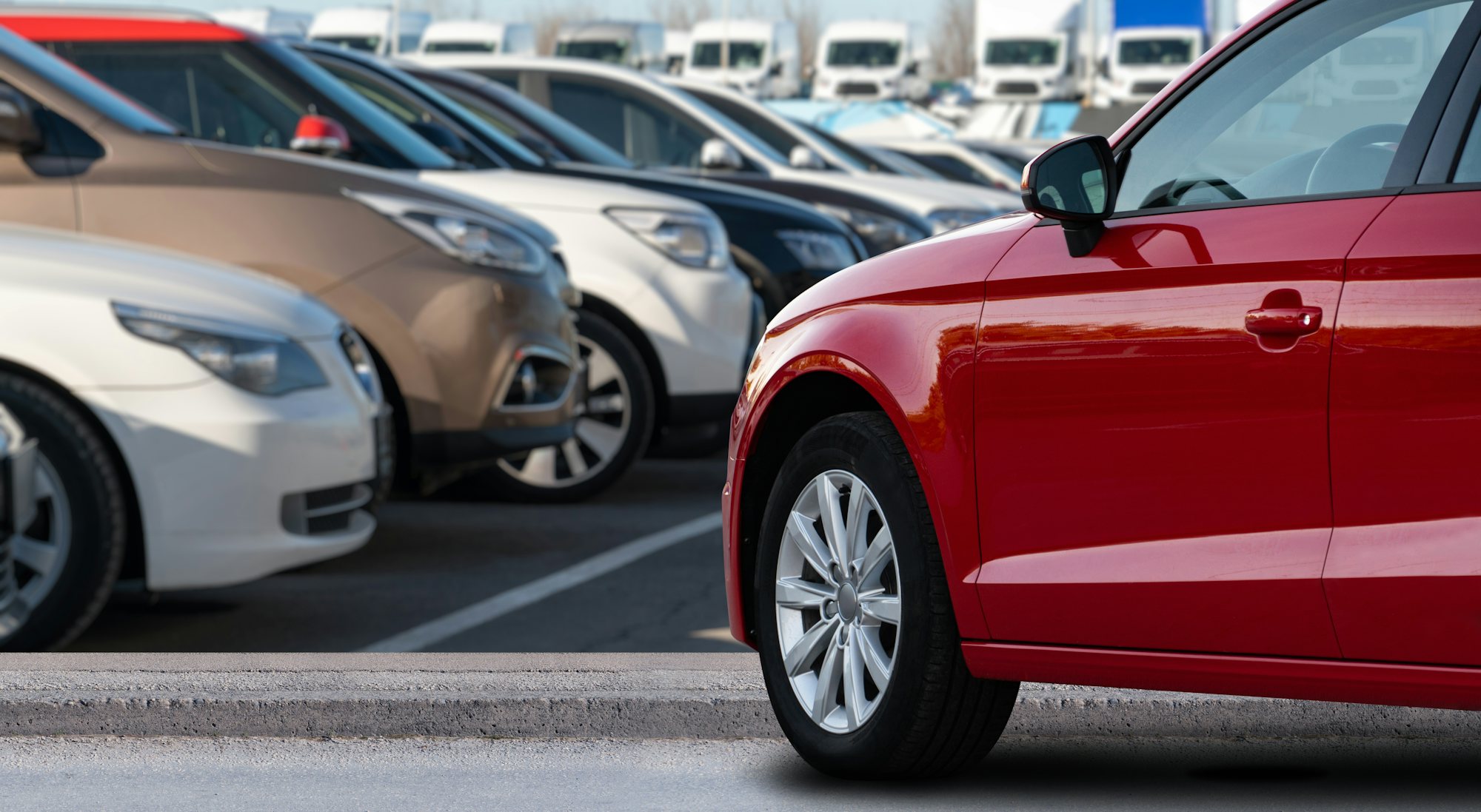 Röd bil på en parkeringsplats.