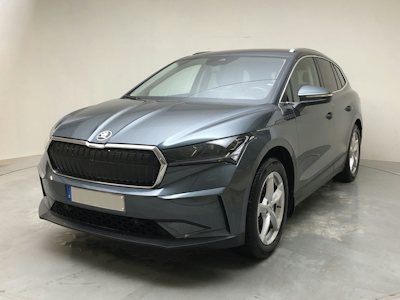 En skoda enyaq iv80 i mörkgrått på en grå platta mot vit bakgrund