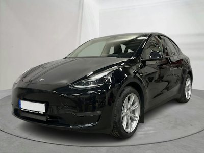En svart Tesla Model Y på en grå platta mot vit bakgrund