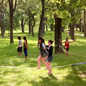 Woman helping another woman on a slackline