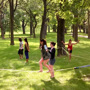 Femme aidant une autre femme sur une slackline