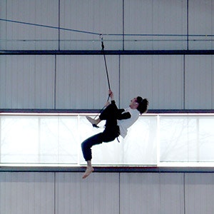 Man in his harness climbing back on a highline